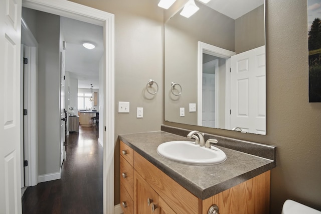 half bathroom with wood finished floors, vanity, and ceiling fan