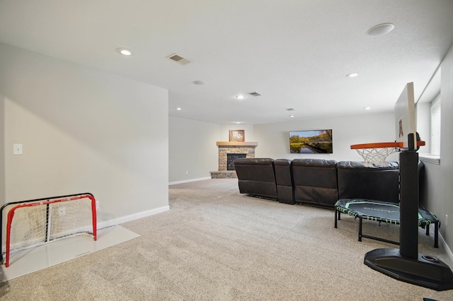 living area featuring carpet floors, a stone fireplace, recessed lighting, and baseboards