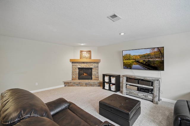 carpeted living room featuring baseboards, a stone fireplace, a textured ceiling, and recessed lighting