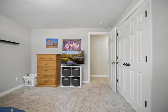 bedroom featuring carpet floors, baseboards, and a textured ceiling