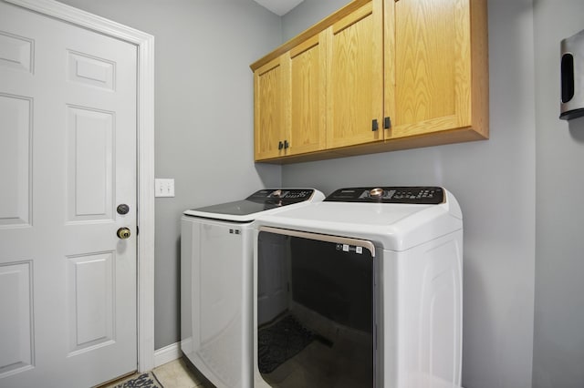 laundry room featuring cabinet space, washer and dryer, baseboards, and light tile patterned floors
