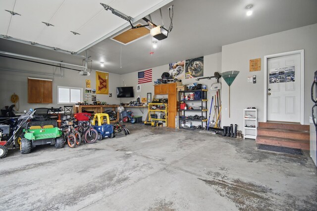 garage featuring a garage door opener and a workshop area