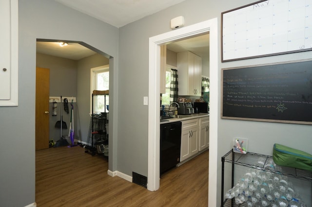 2417 S Ave E, North Saint Paul, MN 55109 - hallway featuring wood finished floors, a sink, baseboards, and arched walkways