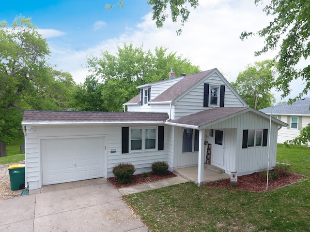 view of front of property with a shingled roof, a garage, driveway, covered porch, and a front lawn