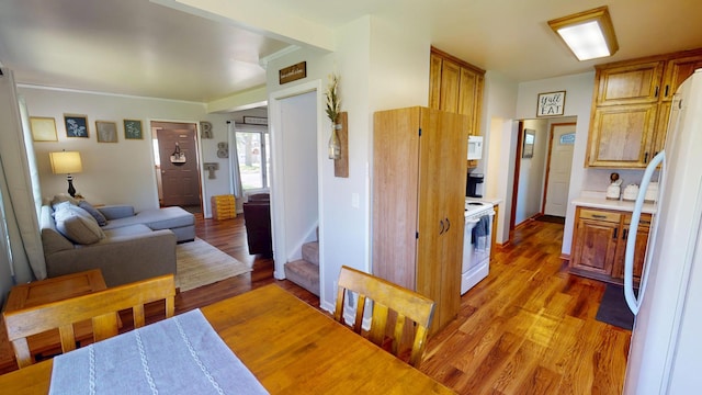 dining space featuring light wood-style flooring and stairway