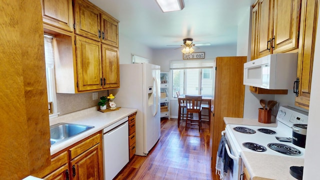 kitchen featuring white appliances, light countertops, wood finished floors, brown cabinetry, and a ceiling fan