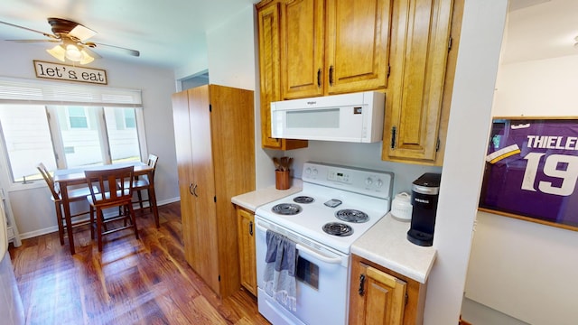kitchen featuring white appliances, light countertops, wood finished floors, a ceiling fan, and brown cabinetry