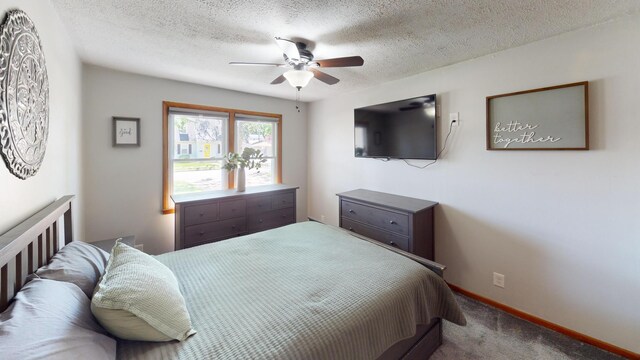 carpeted bedroom featuring a textured ceiling, baseboards, and ceiling fan