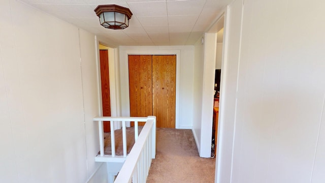 corridor featuring light carpet and an upstairs landing