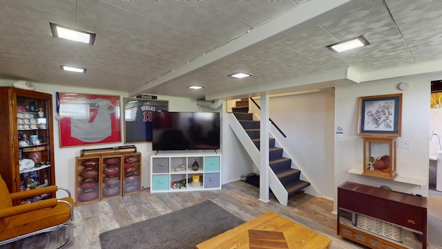 living area featuring wood finished floors and stairway