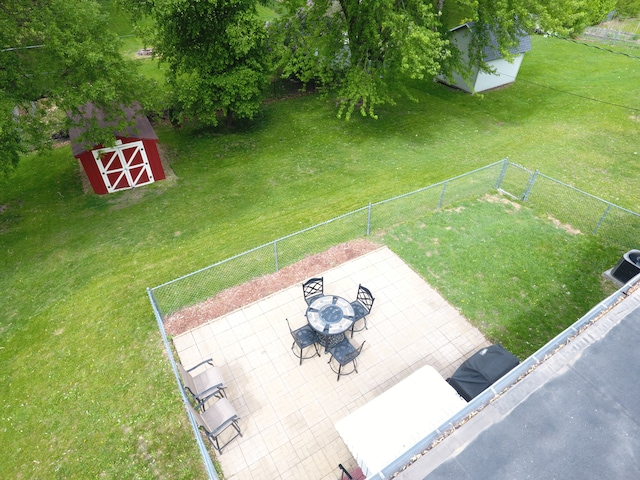 view of yard featuring a shed, an outbuilding, and a patio area