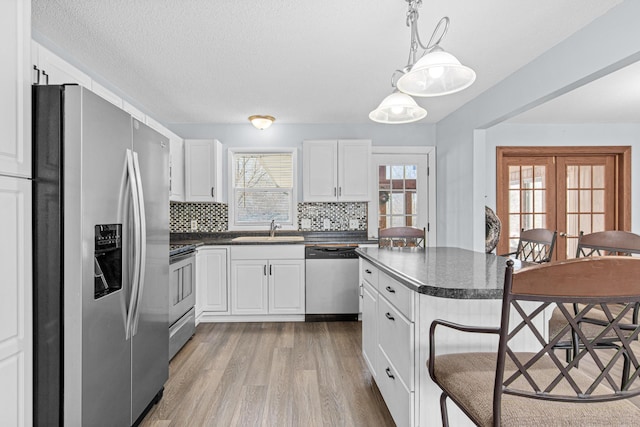 12420 Chippewa Ln, Burnsville, MN 55337 - kitchen featuring appliances with stainless steel finishes, dark countertops, a sink, and light wood-style floors