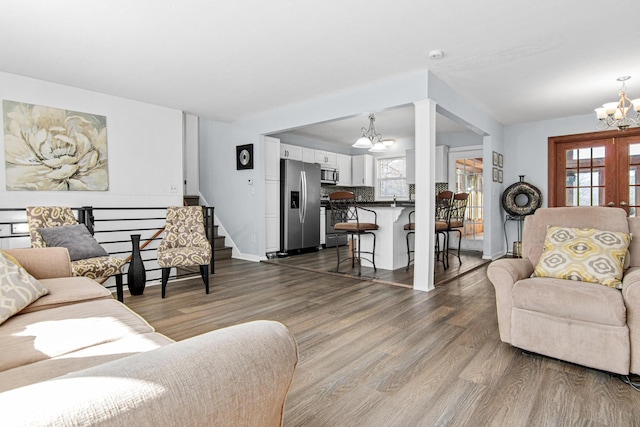 12420 Chippewa Ln, Burnsville, MN 55337 - living room with a chandelier, dark wood finished floors, stairs, and baseboards