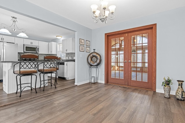 12420 Chippewa Ln, Burnsville, MN 55337 - dining space with a chandelier, french doors, wood finished floors, and baseboards