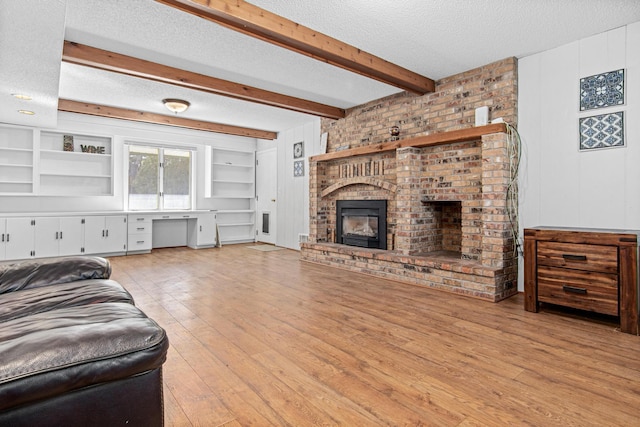 12420 Chippewa Ln, Burnsville, MN 55337 - living room with a textured ceiling, wood-type flooring, a brick fireplace, and beamed ceiling