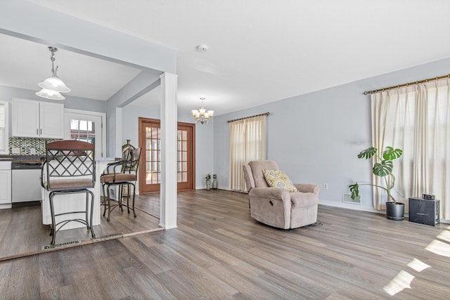 12420 Chippewa Ln, Burnsville, MN 55337 - living area featuring wood finished floors, a chandelier, and baseboards