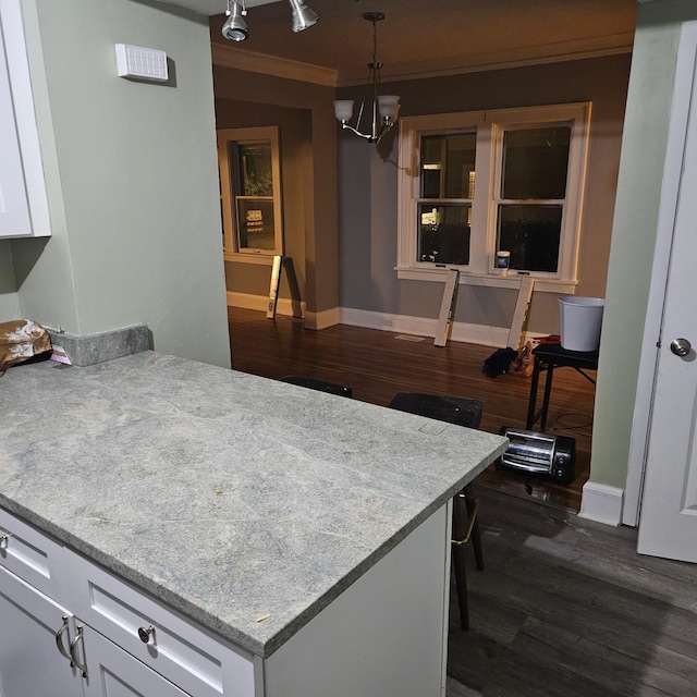 2407 4th St, Minneapolis, MN 55411 - kitchen with dark wood-style floors, white cabinetry, a chandelier, baseboards, and ornamental molding