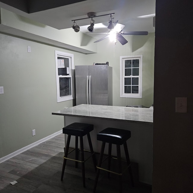 2407 4th St, Minneapolis, MN 55411 - kitchen with freestanding refrigerator, dark wood-type flooring, ceiling fan, baseboards, and a kitchen bar