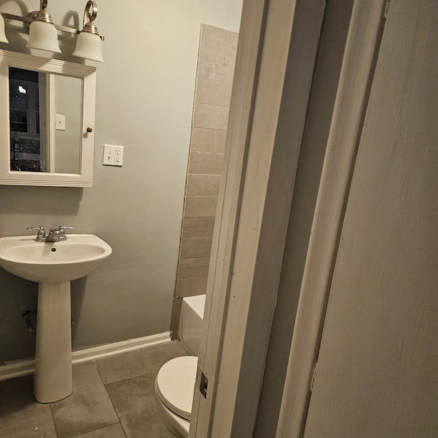 2407 4th St, Minneapolis, MN 55411 - bathroom with toilet, a bathtub, a sink, tile patterned floors, and baseboards