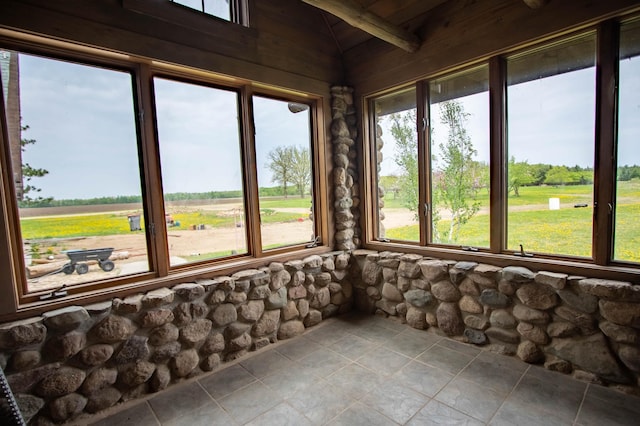 unfurnished sunroom featuring tile patterned floors and lofted ceiling