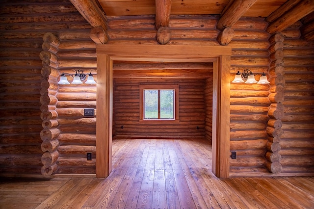 unfurnished living room with beamed ceiling and hardwood / wood-style flooring