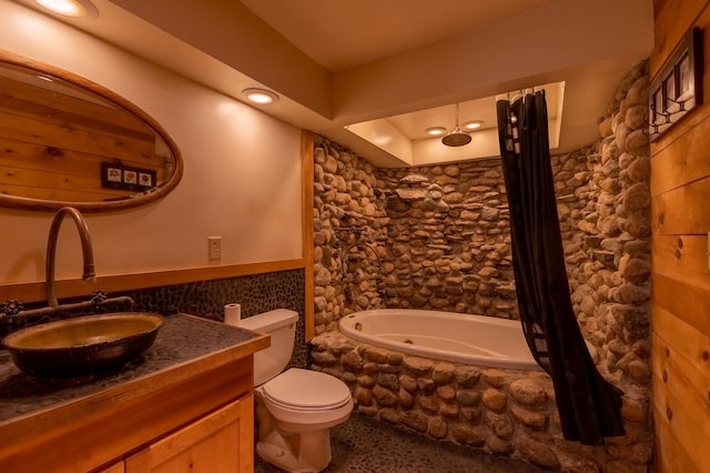 full bathroom with toilet, vanity, tiled shower / bath, and wainscoting