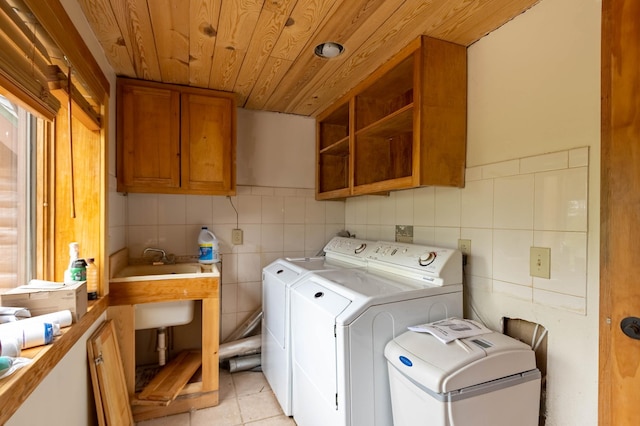 clothes washing area featuring cabinet space, wood ceiling, tile walls, independent washer and dryer, and light tile patterned floors