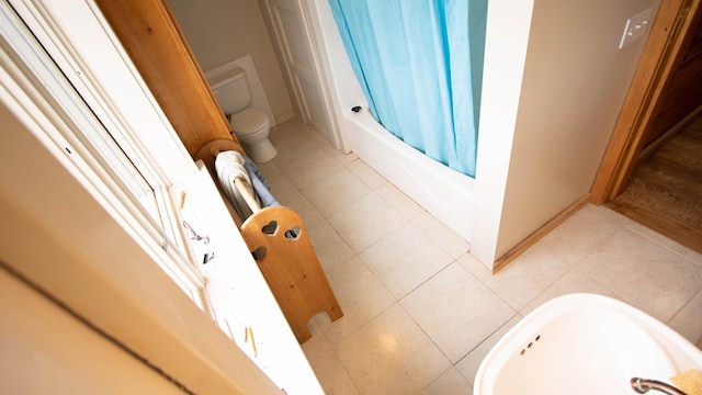 bathroom with toilet, a sink, and baseboards