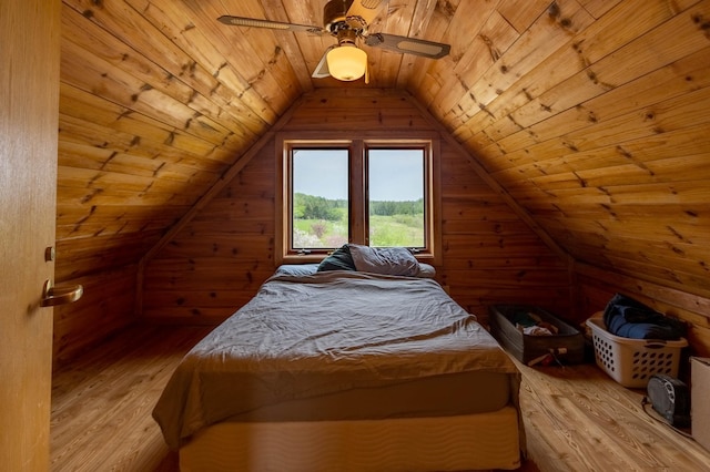 bedroom with wood ceiling, light wood-style floors, wood walls, lofted ceiling, and ceiling fan