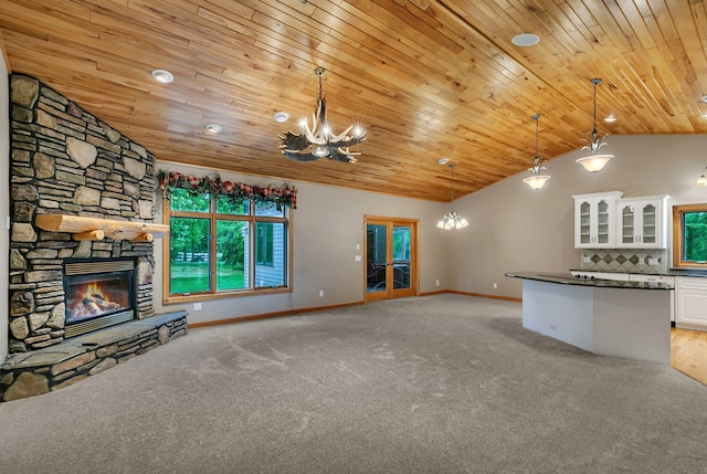 1108 Oak Pond Dr, Sartell, MN 56377 - unfurnished living room featuring a chandelier, wood ceiling, lofted ceiling, light colored carpet, and a stone fireplace