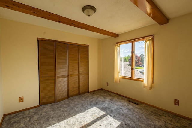 500 Lincoln St, Adams, MN 55909 - unfurnished bedroom featuring beamed ceiling, carpet floors, a closet, and baseboards