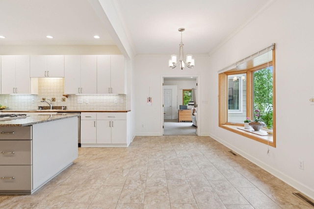 6 Shore Rd, North Oaks, MN 55127 - kitchen with decorative backsplash, a chandelier, ornamental molding, white cabinetry, and pendant lighting