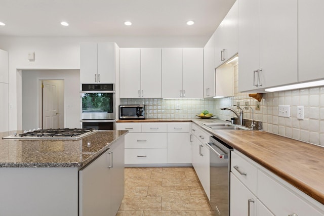 6 Shore Rd, North Oaks, MN 55127 - kitchen featuring appliances with stainless steel finishes, a sink, tasteful backsplash, white cabinets, and stone counters