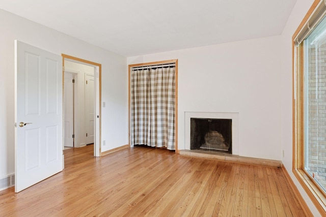 6 Shore Rd, North Oaks, MN 55127 - unfurnished living room featuring light wood-style floors, baseboards, and a fireplace with raised hearth