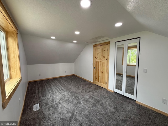 1616 130th Ave, Erin Prairie Twp, WI 54017 - bonus room with vaulted ceiling, dark carpet, a textured ceiling, baseboards, and recessed lighting