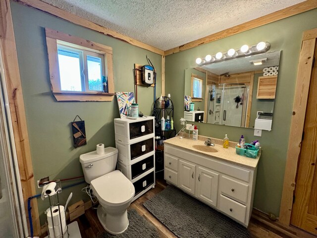 13739 429th Ave, Webster, SD 57274 - full bath featuring toilet, a stall shower, a textured ceiling, wood finished floors, and vanity
