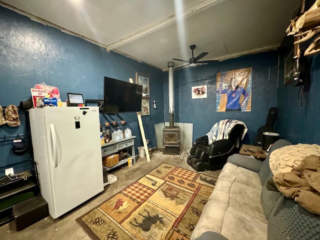 13739 429th Ave, Webster, SD 57274 - living area featuring ceiling fan, a wood stove, and concrete floors