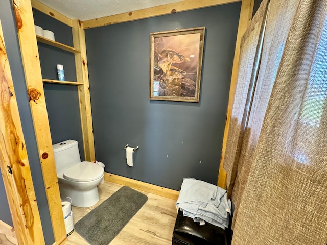 13739 429th Ave, Webster, SD 57274 - bathroom featuring toilet, wood finished floors, a shower with shower curtain, and baseboards