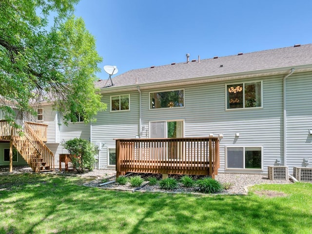 back of property with a wooden deck, a yard, stairs, and central AC unit