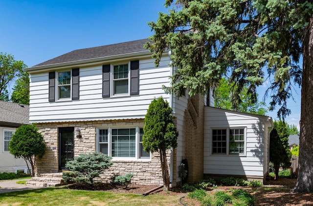 view of front of house with stone siding and a shingled roof