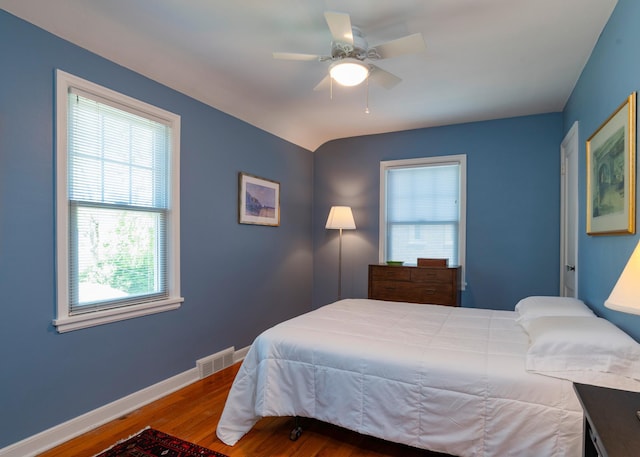 bedroom with wood finished floors, baseboards, and a ceiling fan