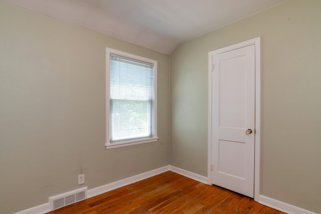 spare room featuring wood finished floors and baseboards