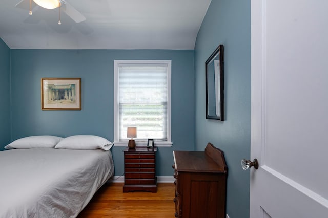 bedroom featuring wood finished floors, baseboards, and a ceiling fan