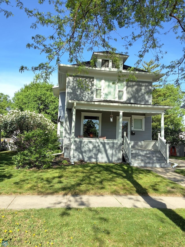 american foursquare style home with covered porch and a front yard