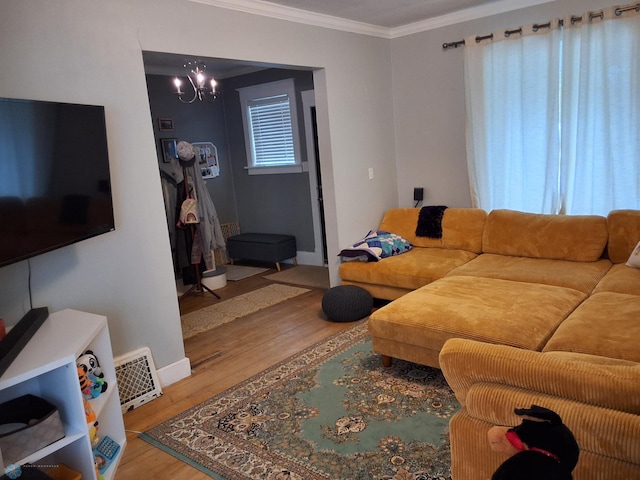 living room featuring wood finished floors, crown molding, a chandelier, and baseboards