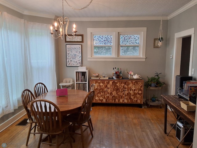 dining room with hardwood / wood-style flooring, a chandelier, and ornamental molding