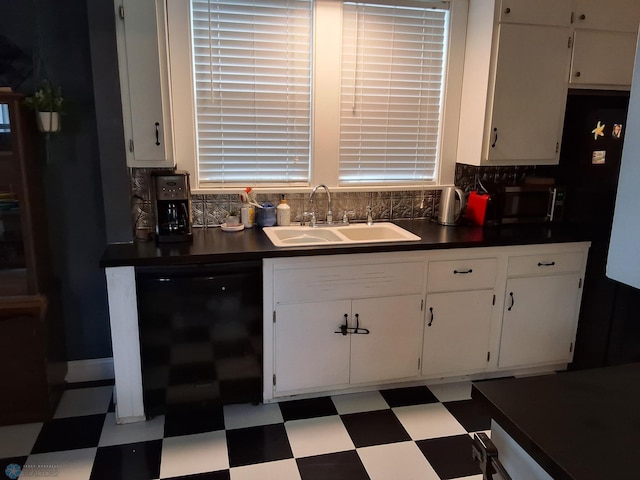 kitchen with tile patterned floors, a sink, dishwasher, and dark countertops