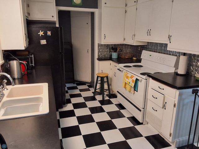 kitchen with white electric range oven, light flooring, a sink, white cabinets, and decorative backsplash