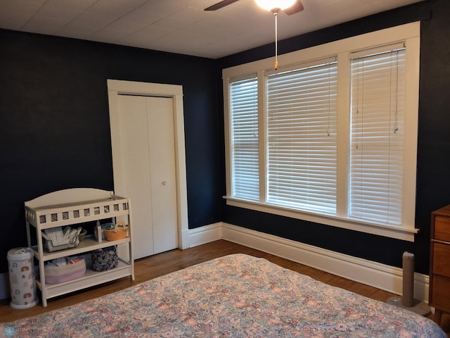 bedroom with wood finished floors, baseboards, multiple windows, and ceiling fan