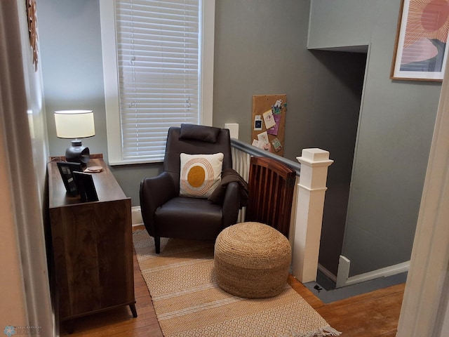 sitting room featuring wood finished floors and an upstairs landing